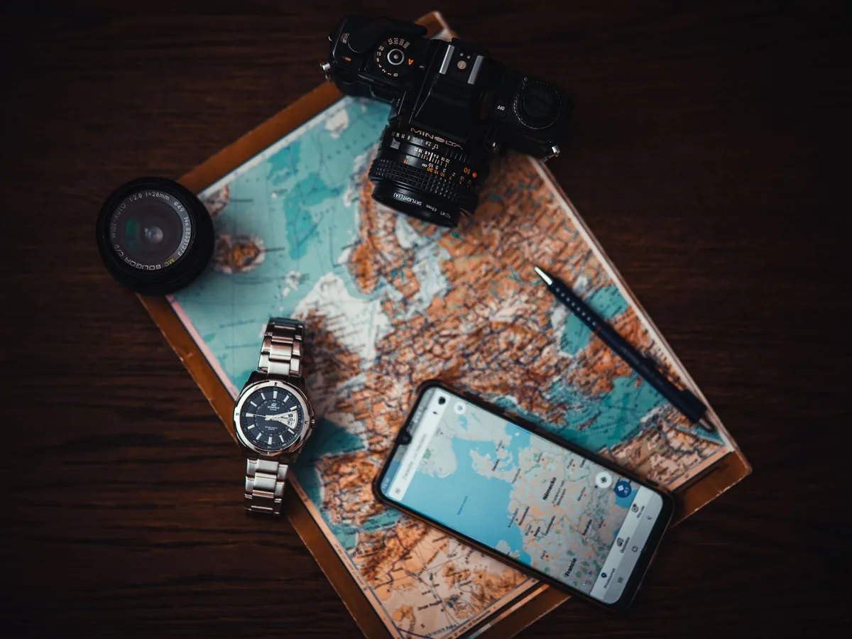 Un artisan consulte son smartphone devant son atelier, la fiche de son entreprise visible sur Google Maps