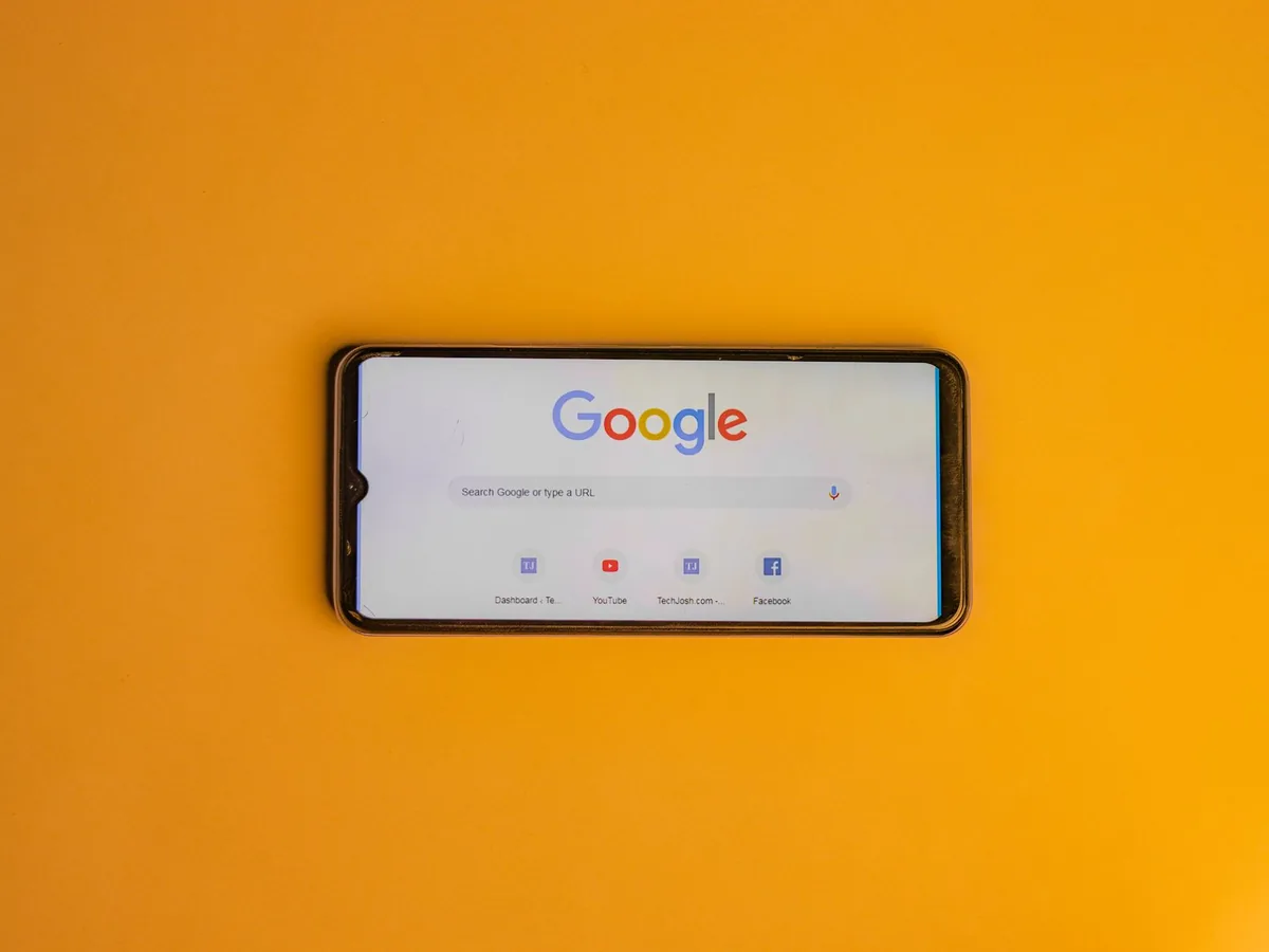 Un smartphone affichant une fiche d'établissement Google avec la mention d'un avis acheté signalé et retiré