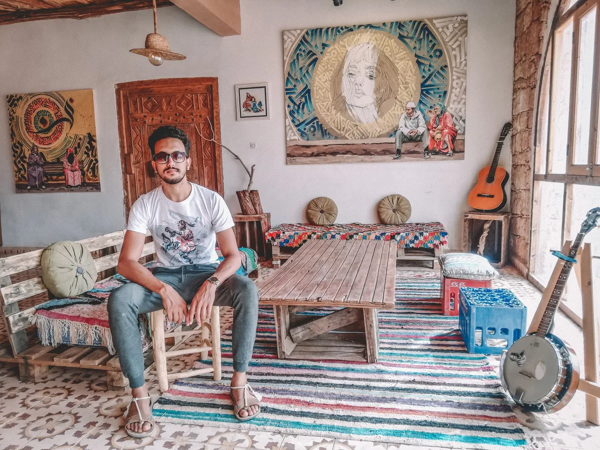 Photographe installé dans une zone d'activité, tenant son appareil dans son studio éclairé