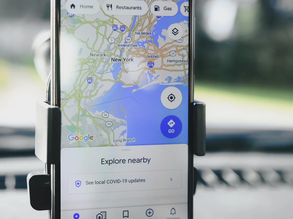 Un artisan consulte la fiche de son entreprise sur Google Maps depuis son smartphone dans son atelier.