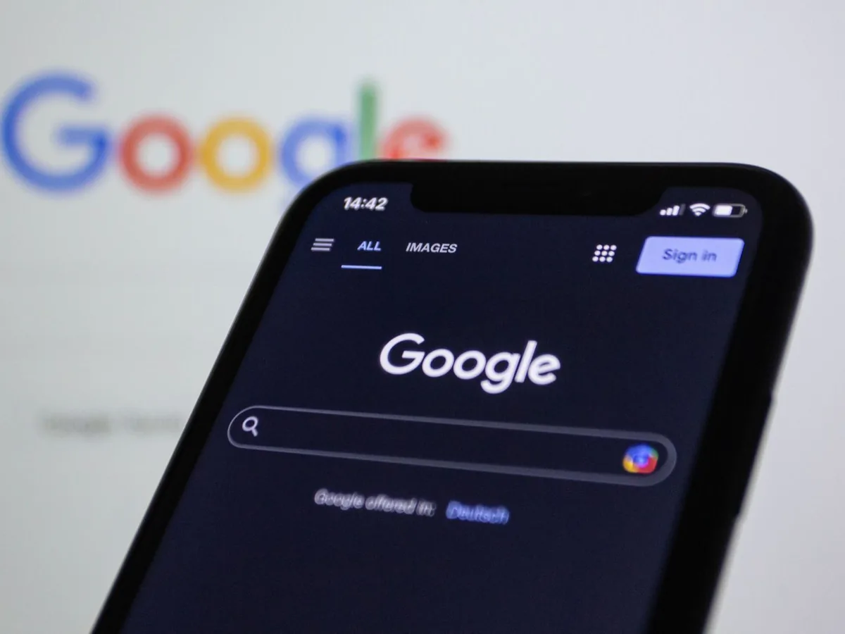Un artisan consulte la fiche d'établissement de son entreprise sur un smartphone dans son atelier.