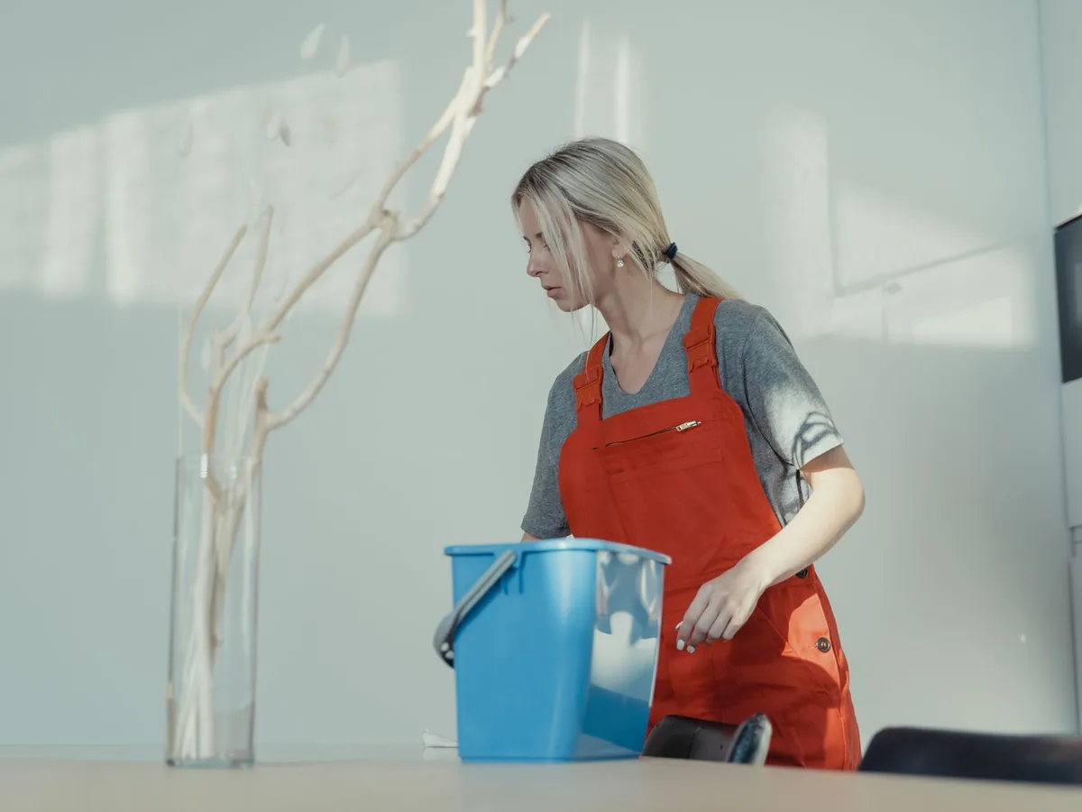 Une réalisatrice filme sur smartphone une femme s'exprimant face caméra dans un salon de séjour ensoleillé.