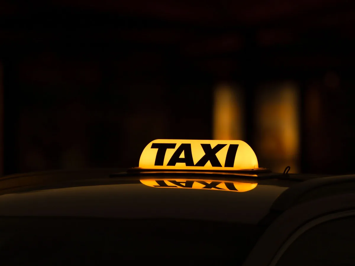 Chauffeur de taxi remettant un devis imprimé à un client devant son véhicule