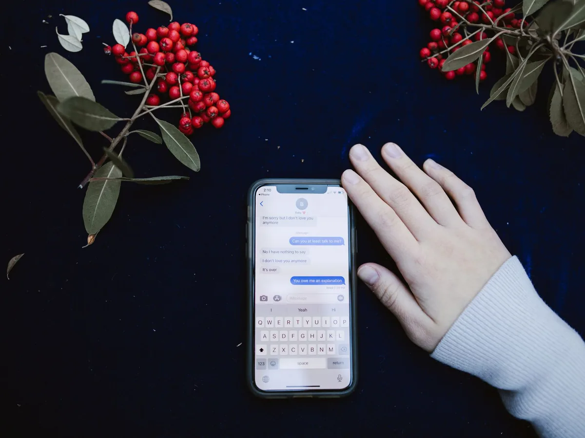 Une personne consultant un message reçu sur son smartphone à propos d'un rendez-vous de kinésithérapie.