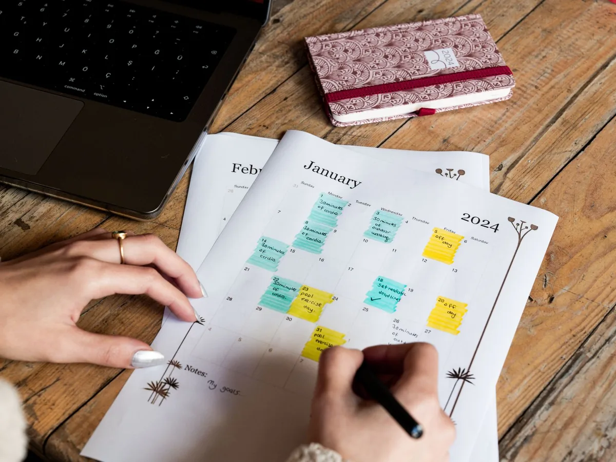 Artisan consultant son planning de rendez-vous en ligne sur un smartphone dans son atelier