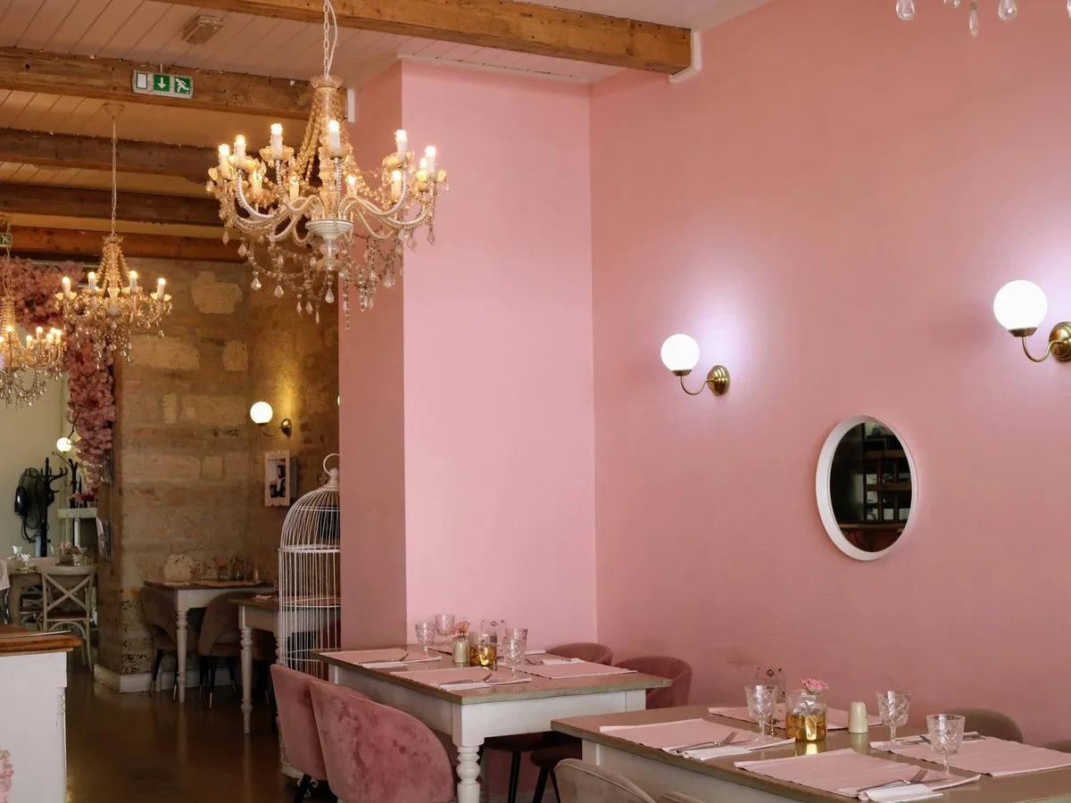 Personne réglant sur smartphone une réservation de table dans un restaurant avant le service du soir.