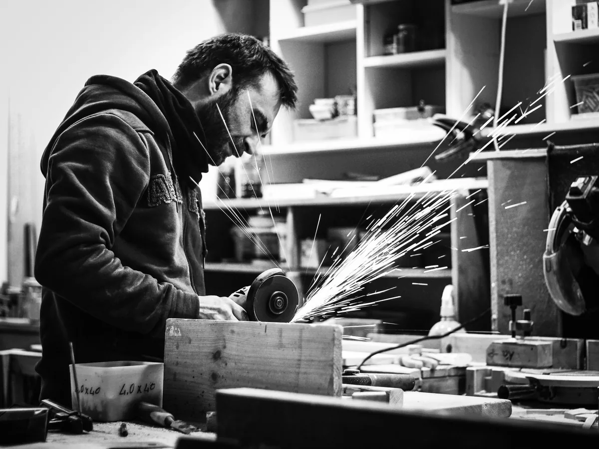 Artisan dans son atelier consultant sur son smartphone le budget de création de son site web